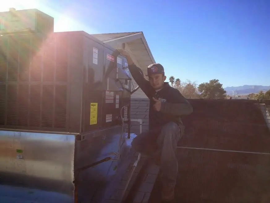 HVAC technician performing Boiler Repair on a rooftop unit in Newport